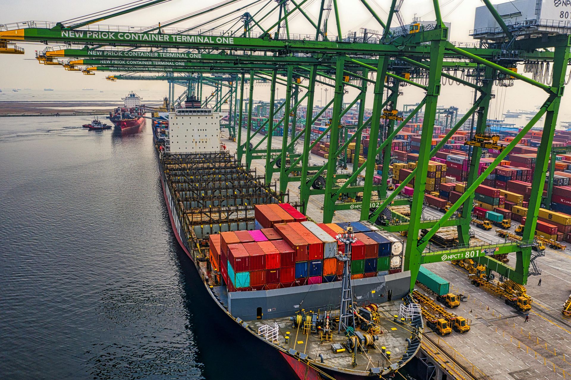Aerial view of a container terminal with cranes loading a vessel